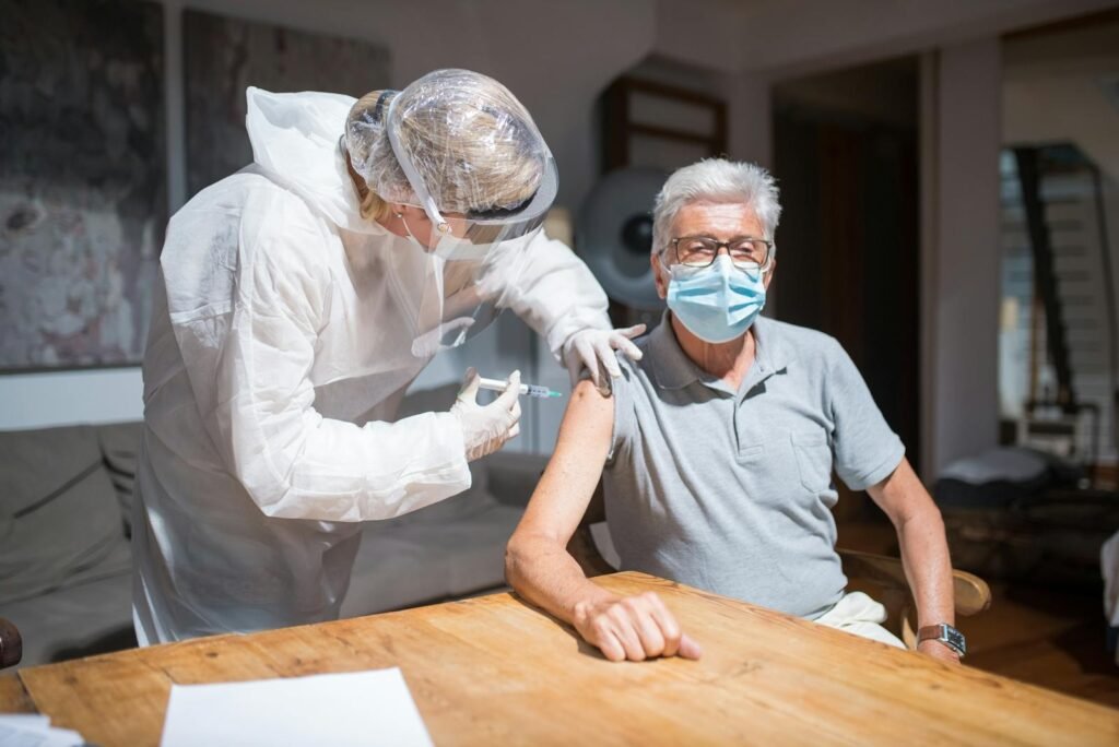 Elderly Man in Gray Polo Shirt with Face Mask Having Vaccination